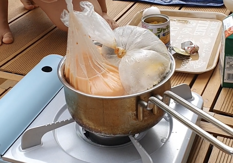 トマトのスープの材料を入れた袋を、焼き鳥ごはんの入った袋と同じ鍋に入れます